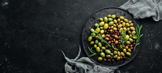 Olives in a bowl, olive oil, spices and herbs. Top view. Free space for your text.