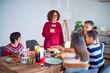 © Krakenimages.com - Beautiful family smiling happy and confident. One of them standing holding cup of wine speaking speech celebrating thanksgiving day at home