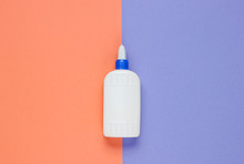Bottle Of Glue On A Color Studio Paper Background. Top View