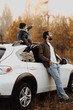 © Olena Bloshchynska - Happy father stanting near the car with his son sitting on car and pointing at sky.