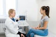 © Kate - the doctor advises the patient's girl after an ultrasound diagnosis. indicates with a pen on the monitor of the ultrasound machine the problematic place to which the patient should pay special