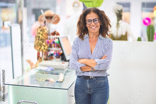 Fotografía Middle age beautiful clothes shop owner woman smiling happy and confident waitin
