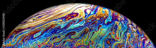Fotomural Macro picture of half soap bubble psychedelic color on black background