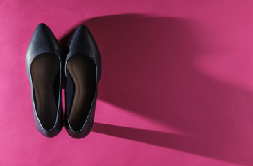 Classic women's high heel shoes on pink paper background. Stylish shoes. Studio shot. Minimalistic fashion still life.