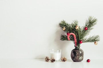 Composition with little Christmas tree and candles. Minimalist interior decoration. Copy space for lettering