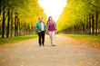 © Alejandro - Couple walking in the long path of the public park.