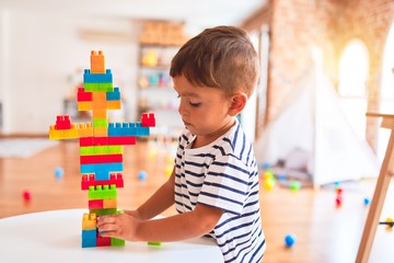 Wall Mural - Beautiful toddler boy playing with construction blocks at kindergarten