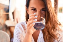 Young Beautiful Woman Sitting At Restaurant Enjoying Summer Vacation Drinking A Glass Of Water