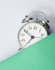 Wall Mural - Half alarm clock on green-gray background. Retro style 80s. Top view