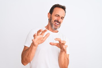 Middle age handsome man wearing casual t-shirt standing over isolated white background disgusted expression, displeased and fearful doing disgust face because aversion reaction. With hands raised