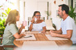 © Krakenimages.com - Beautiful family sitting on terrace drinking cup of coffee speaking and smiling