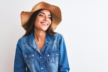 Young Beautiful Woman Wearing Denim Shirt And Hat Standing Over Isolated White Background Looking Away To Side With Smile On Face, Natural Expression. Laughing Confident.