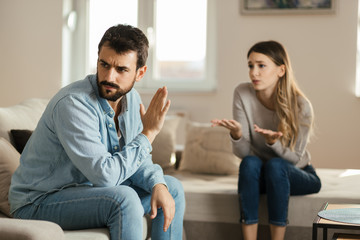 Wall Mural - Angry man doesn't pay attention to his girlfriend who is asking for his forgiveness