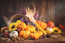Pumpkins With Fruits And Falling Leaves On Rustic Wooden Table