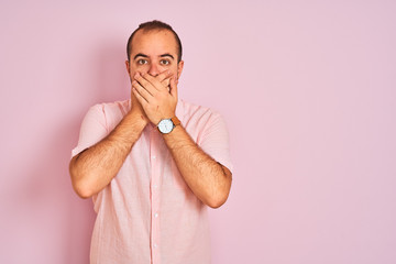 Sticker - Young man wearing elegant shirt standing over isolated pink background shocked covering mouth with hands for mistake. Secret concept.