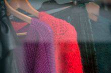 Closeup Of Colorful Woolen Pullover On Hangers In A Woman Fashion Store Showroom