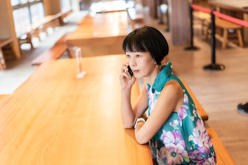 Wall Mural - woman talk on cellphone at a coffee shop