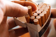 © Mihail - close up person's hand pick a cigarette from the carton pack box