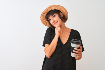 Beautiful woman wearing summer hat drinking take away coffee over isolated white background serious face thinking about question, very confused idea