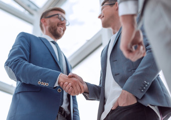 Wall Mural - close up. background image of a business handshake in the office lobby.