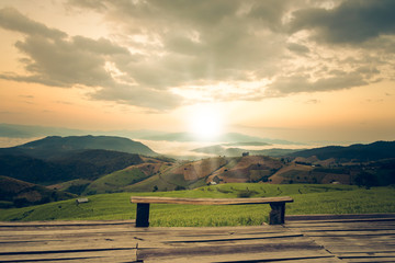 landscape images of wood balcony and morning light on high mountain range covers the green rice fiel