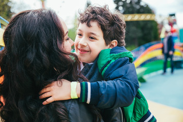 Wall Mural - Cute cheerful child with mother play outdoors in park.