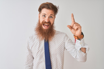 Poster - Young redhead irish businessman standing over isolated white background pointing finger up with successful idea. Exited and happy. Number one.