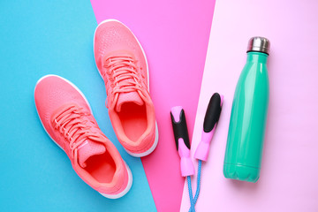 Wall Mural - Sports water bottle, shoes and jumping rope on color background