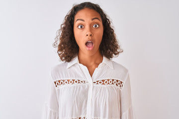 Wall Mural - Young brazilian woman wearing shirt standing over isolated white background scared in shock with a surprise face, afraid and excited with fear expression