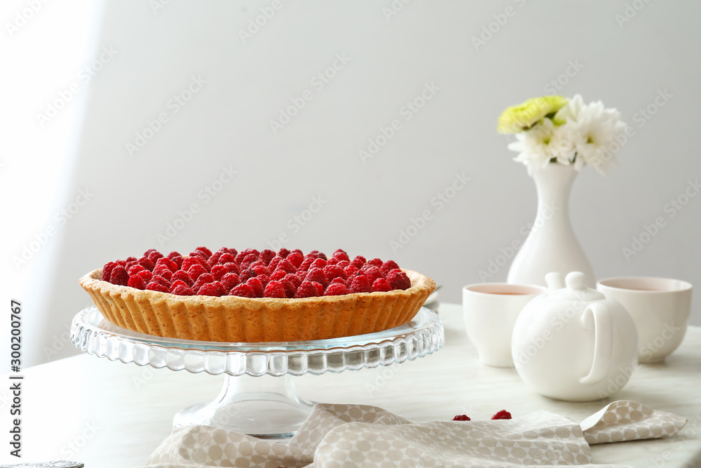 Tasty raspberry pie and tea set on table