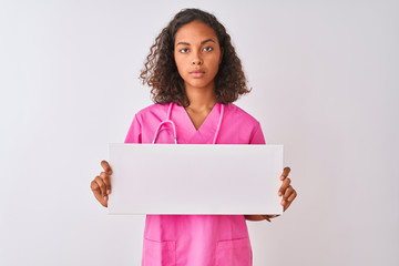 Canvas Print - Young brazilian nurse woman holding banner standing over isolated white background with a confident expression on smart face thinking serious