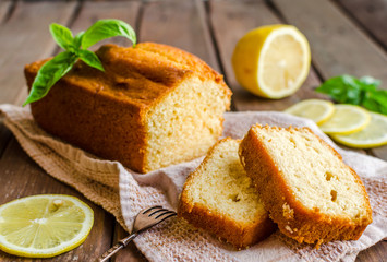 Lemon pound cake on rustic wooden background with lemon.