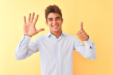 Young handsome businessman wearing elegant shirt over isolated yellow background showing and pointing up with fingers number six while smiling confident and happy.