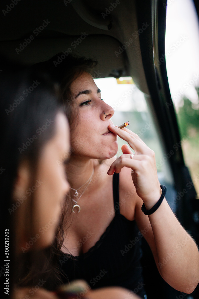 Two young lesbians smoking inside a car Stock Photo
