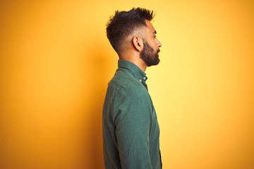 Wall Mural - Young indian businessman wearing elegant shirt standing over isolated white background looking to side, relax profile pose with natural face with confident smile.