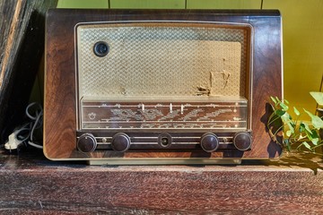 Old vintage radio set on a wooden shelf