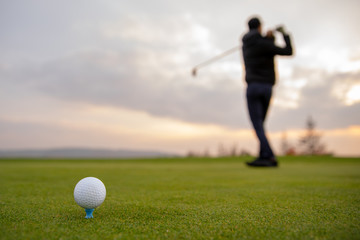 Wall Mural - A golf player prepares the ball to be fired at the golf course