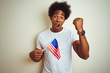 © Krakenimages.com - Afro man holding United Estates of America USA flag standing over isolated white background annoyed and frustrated shouting with anger, crazy and yelling with raised hand, anger concept