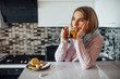 © Тарас Нагирняк - Portrait of young ill woman drinking cup of hot tea at home kitchen.