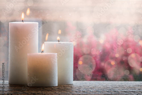 Fotografía White burning candles with bokeh.