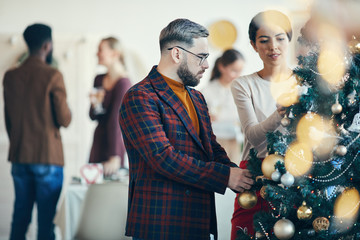 Poster - Side view portrait of modern adult man looking at Christmas decorations during banquet party, copy space