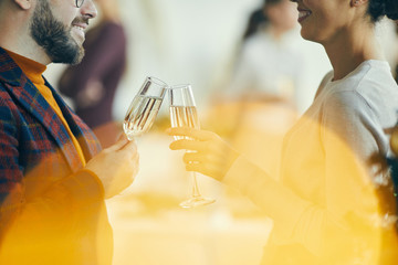 Wall Mural - Close up of adult couple drinking champagne and talking during Christmas party, golden flare overlay