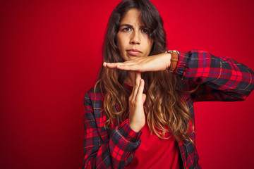 Wall Mural - Young beautiful woman wearing casual jacket standing over red isolated background smiling doing talking on the telephone gesture and pointing to you. Call me.