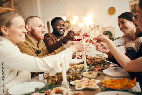 Fotomural Multi-ethnic group of people raising glasses sitting at beautiful dinner table c