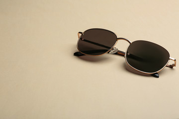 Stylish sunglasses on beige background, space for text. Fashionable accessory