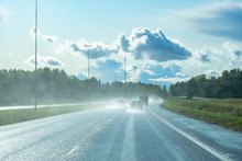 Cars Drive On A Wet Road. Highway After The Rain. Water Spray From A Car Ride. Car Track. Splashes From Under The Wheels Of Cars. Roads Of Russia. Country Road. Concept - Riding In The Country.