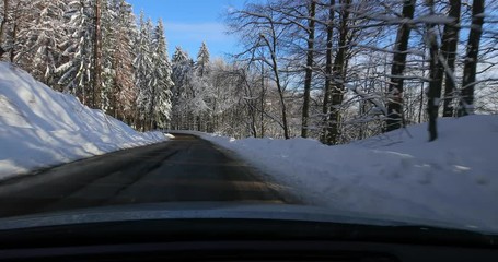 Wall Mural - Driving on a scenic winter mountain road with snow and trees