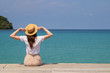 © allenkayaa - Young woman in a hat sits on a pier near the clear turquoise sea