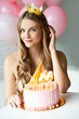 Happy pretty girl with cream cake and pink balloons at birthday party.  Barbie style. Princess.  16 years old girl.