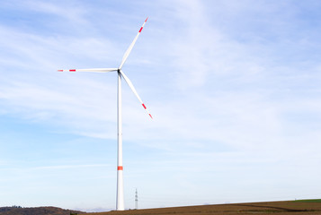 A windmill on a field with blue sky